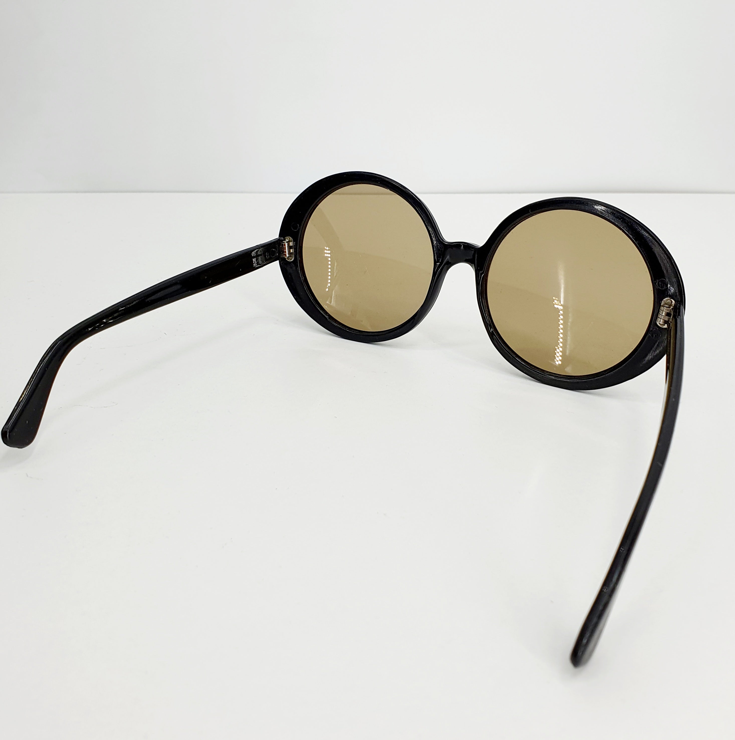 Round black sunglasses in the style of the 60s