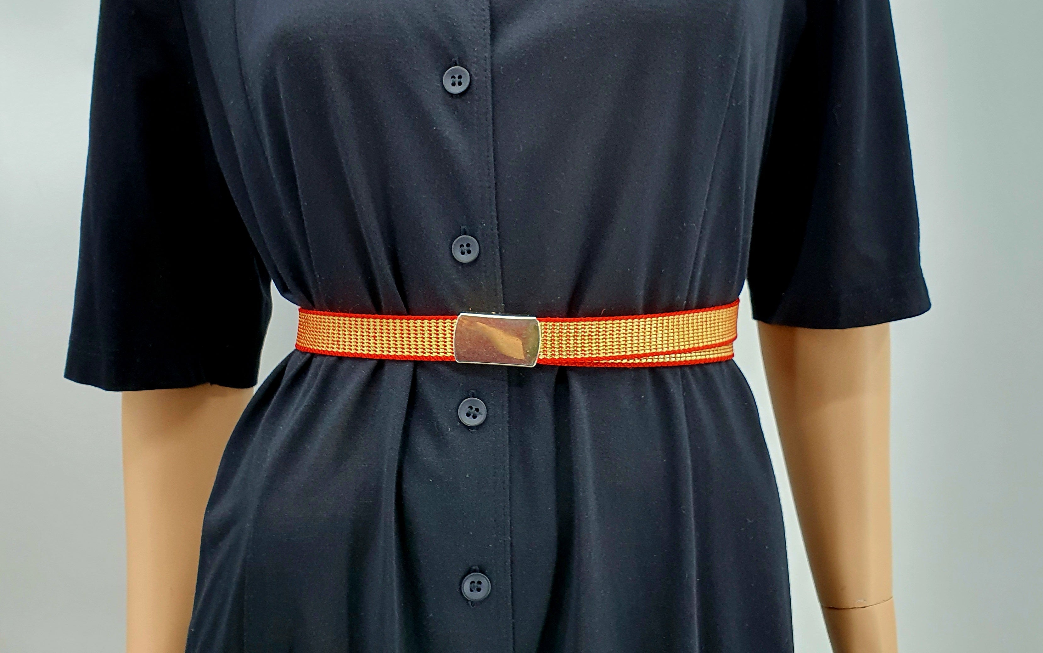 Kapea vintagevyö 80-luvulta, väritys punainen-kulta, kuva mallinuken päällä