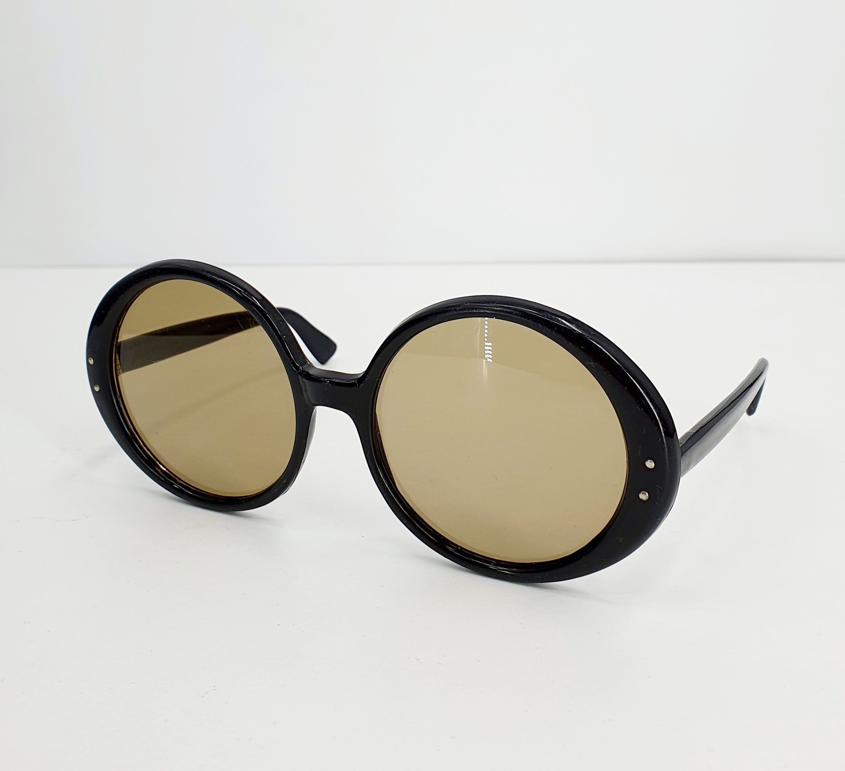 Round black sunglasses in the style of the 60s