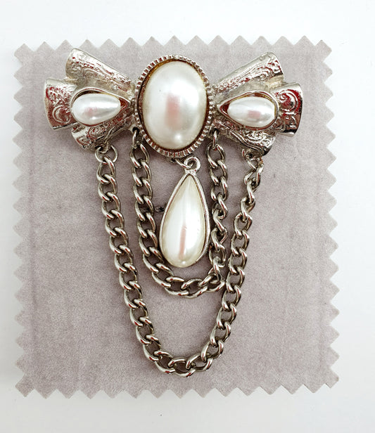 Bow-shaped brooch with chains