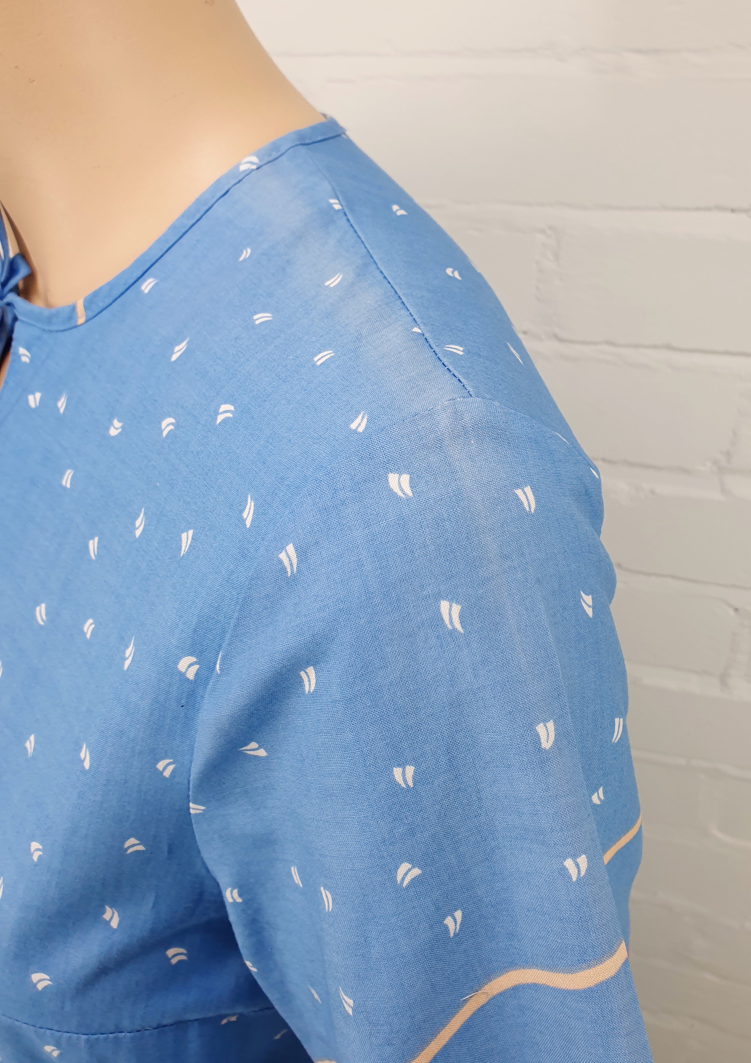 Tiklas, sininen puuvillamekko 80-luvulta, lyhythihainen, kuva haalistuneesta kankaasta olalla