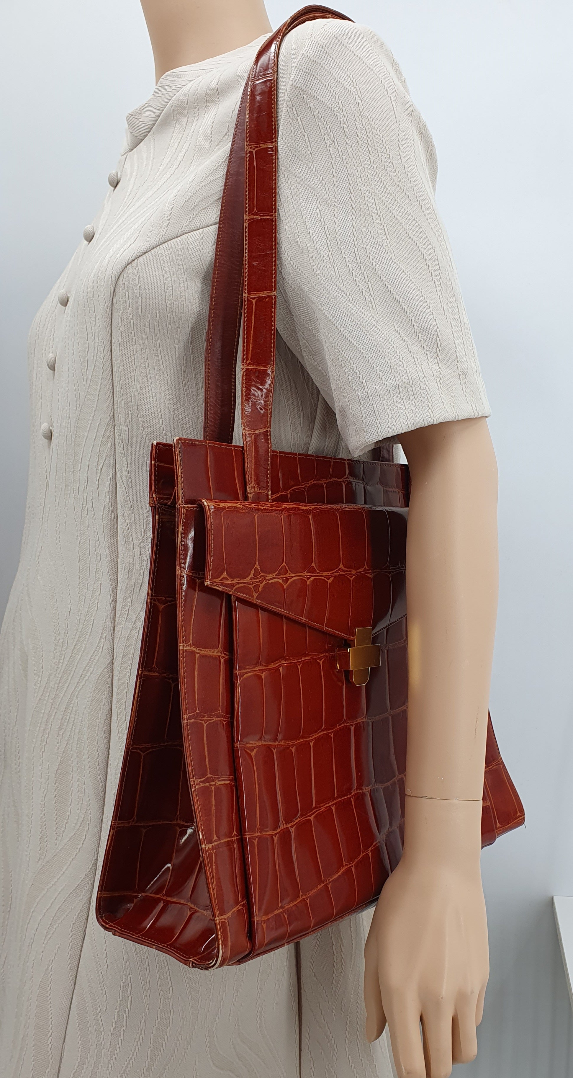 Matelijakuvioinen shopper bag 90-luvulta, väri oranssinruskea, laukku mallinuken olalla