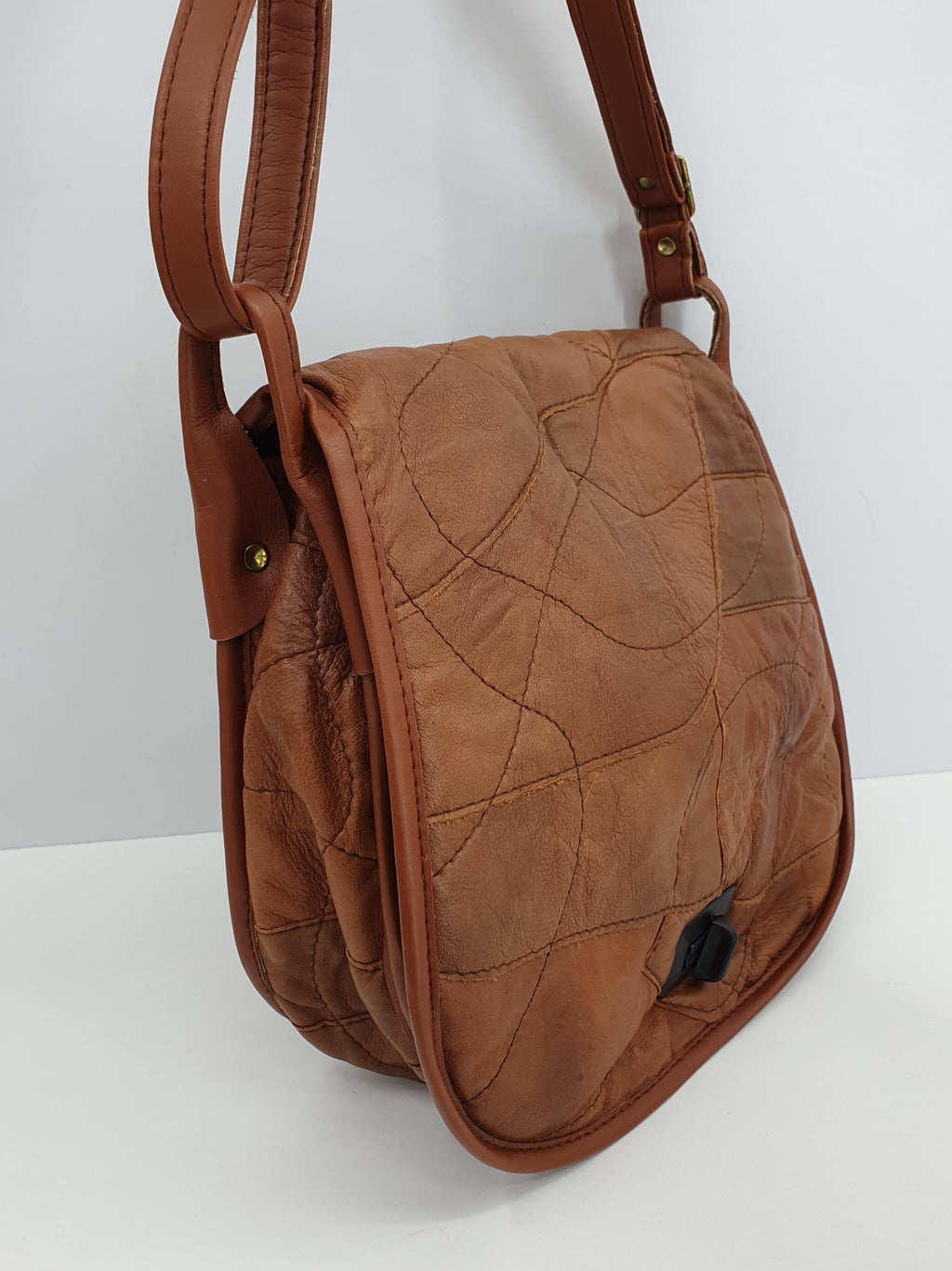 Ruskea nahkapalalaukku käsityönä valmistettu Kuva sivusta