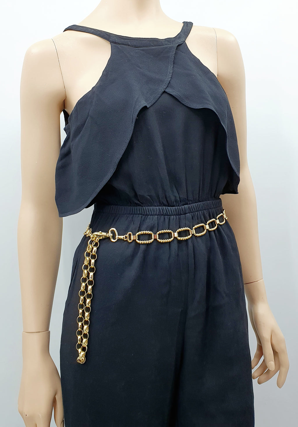 Kullanvärinen lannevyö 90-luvulta, metallia, papukaijalukko, kuva vyöstä mallinuken päällä