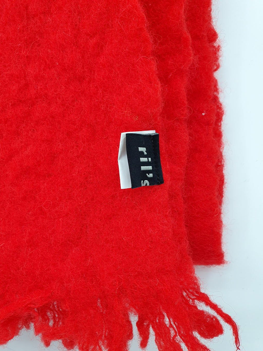 Ril`s punainen villahuivi 2000-luvulta, lähikuva logosta