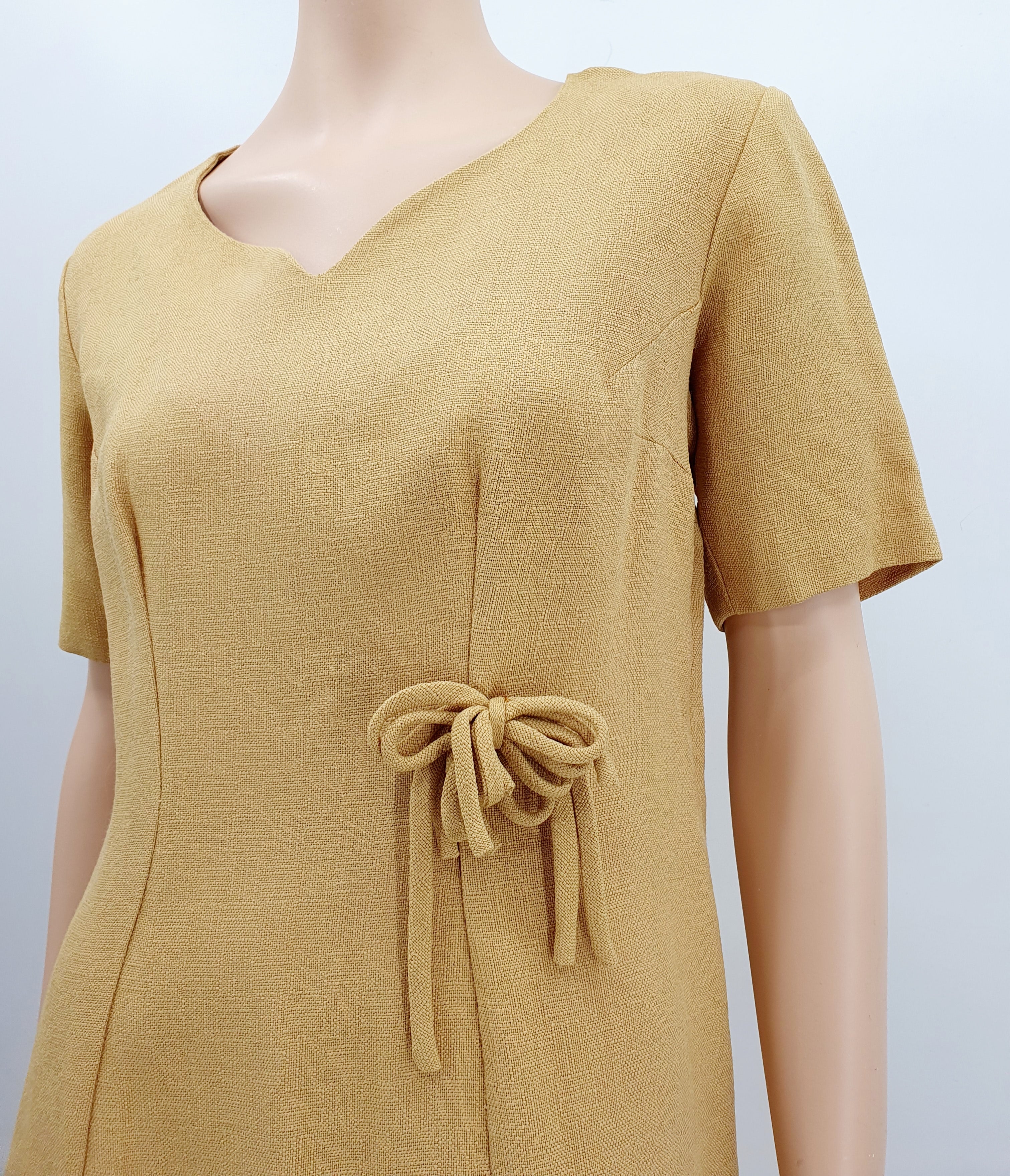 Sinapinkeltainen juhlamekko 1950-luvulta, lähikuva rusetista