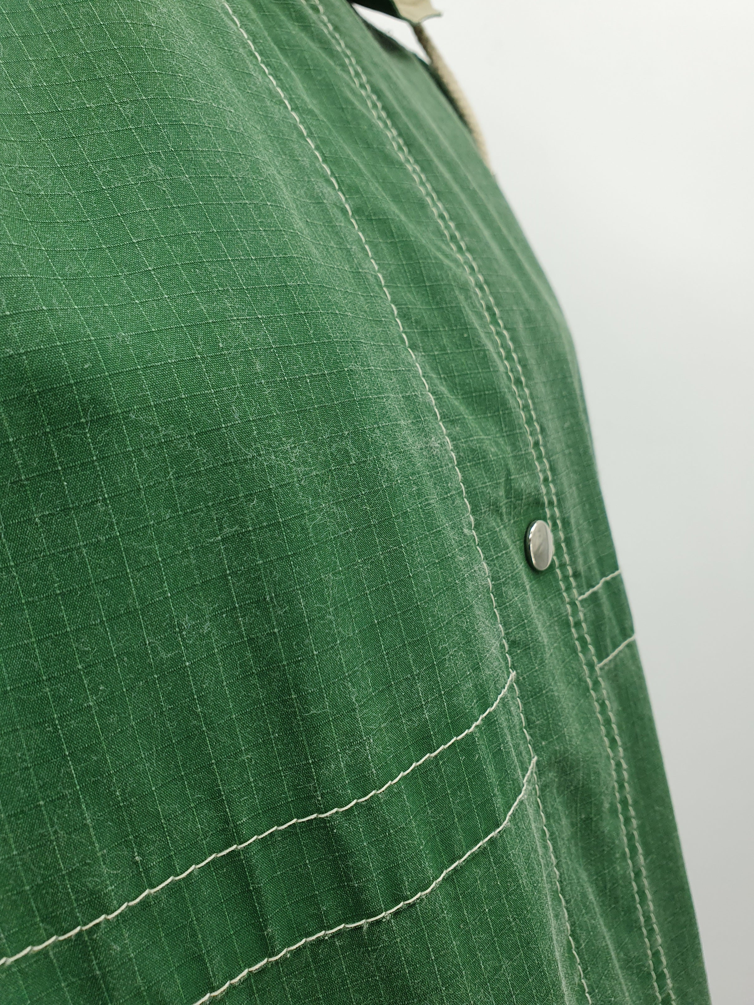 Kosteuttapitävä välikausitakki 90-luvulta, väri vihreä-luunvalkoinen, kuva kankaan pinnasta