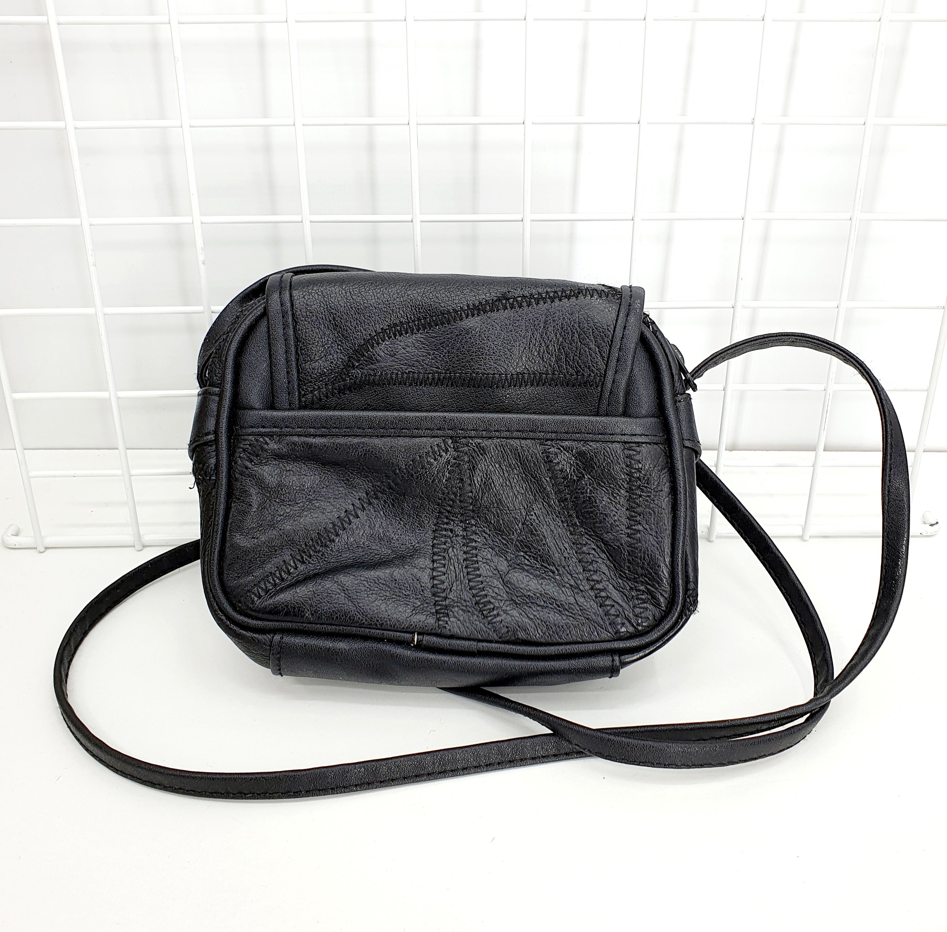 Musta nahkapalakuvioinen olkalaukku 90-luvulta, kuva takaa