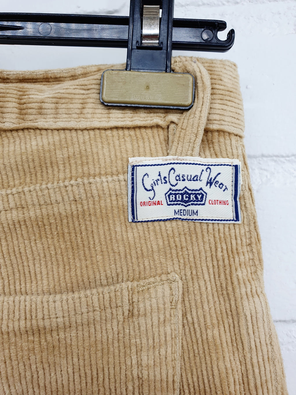 Beigen väriset vakosamettihousut, vintagesammarit 90-2000-luvulta, kuva logosta