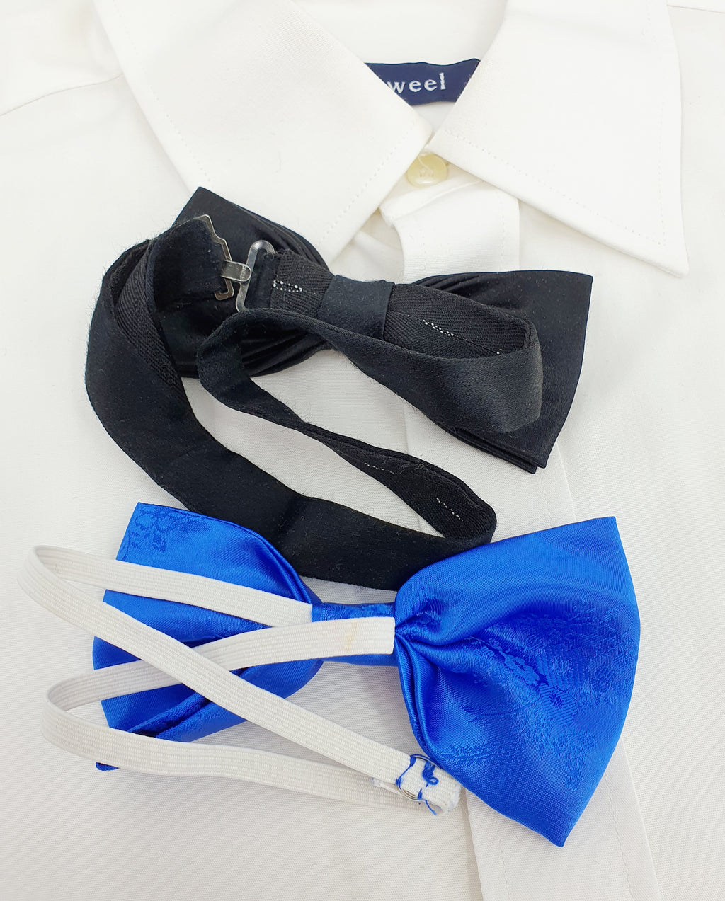 Kaksi satiinirusettia 90-luvulta, musta ja sininen, kuva takaa