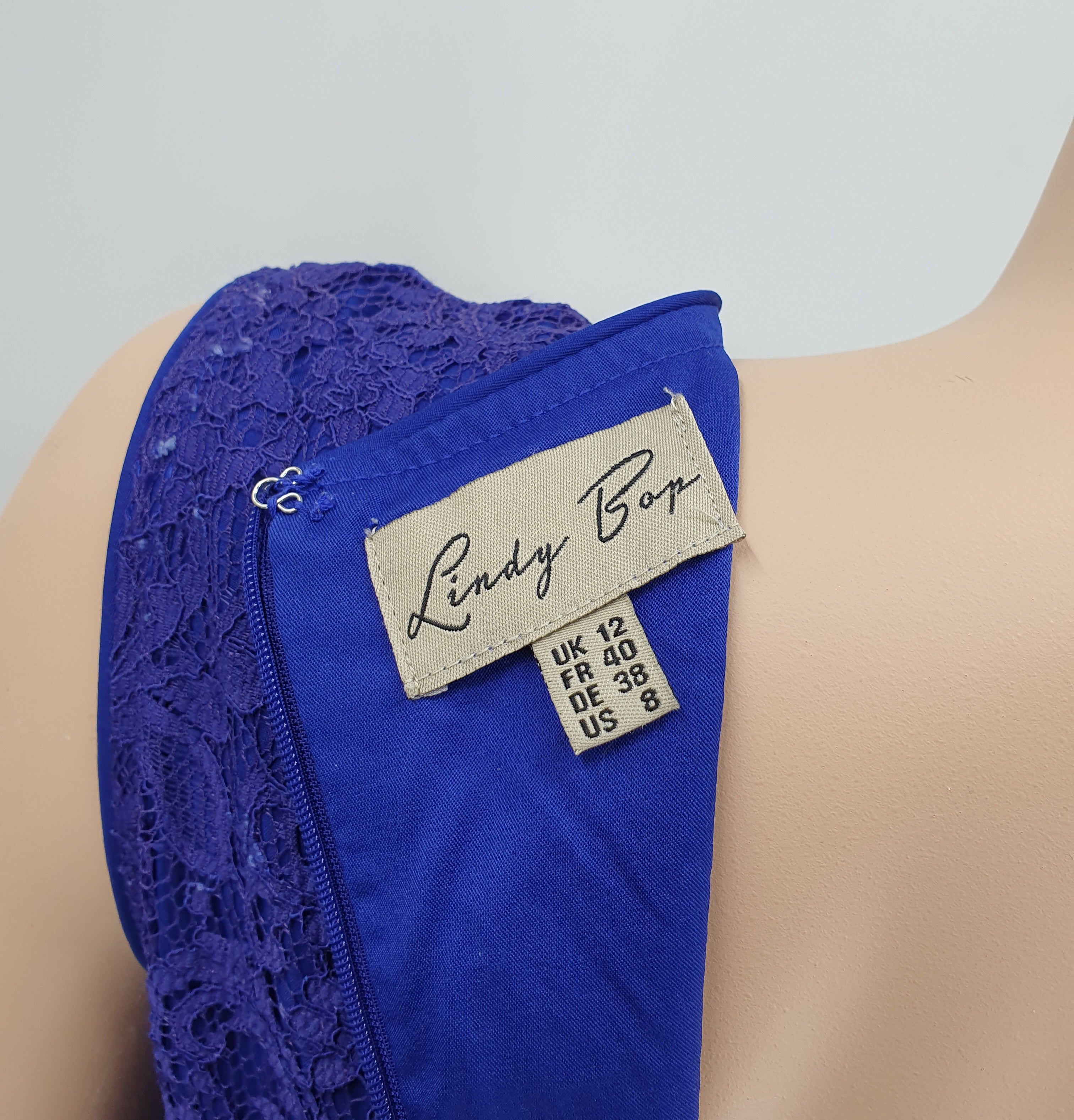 Lindy Pop, laventelinvärinen pitsimekko, 2000-luku, kuva tuotelapusta