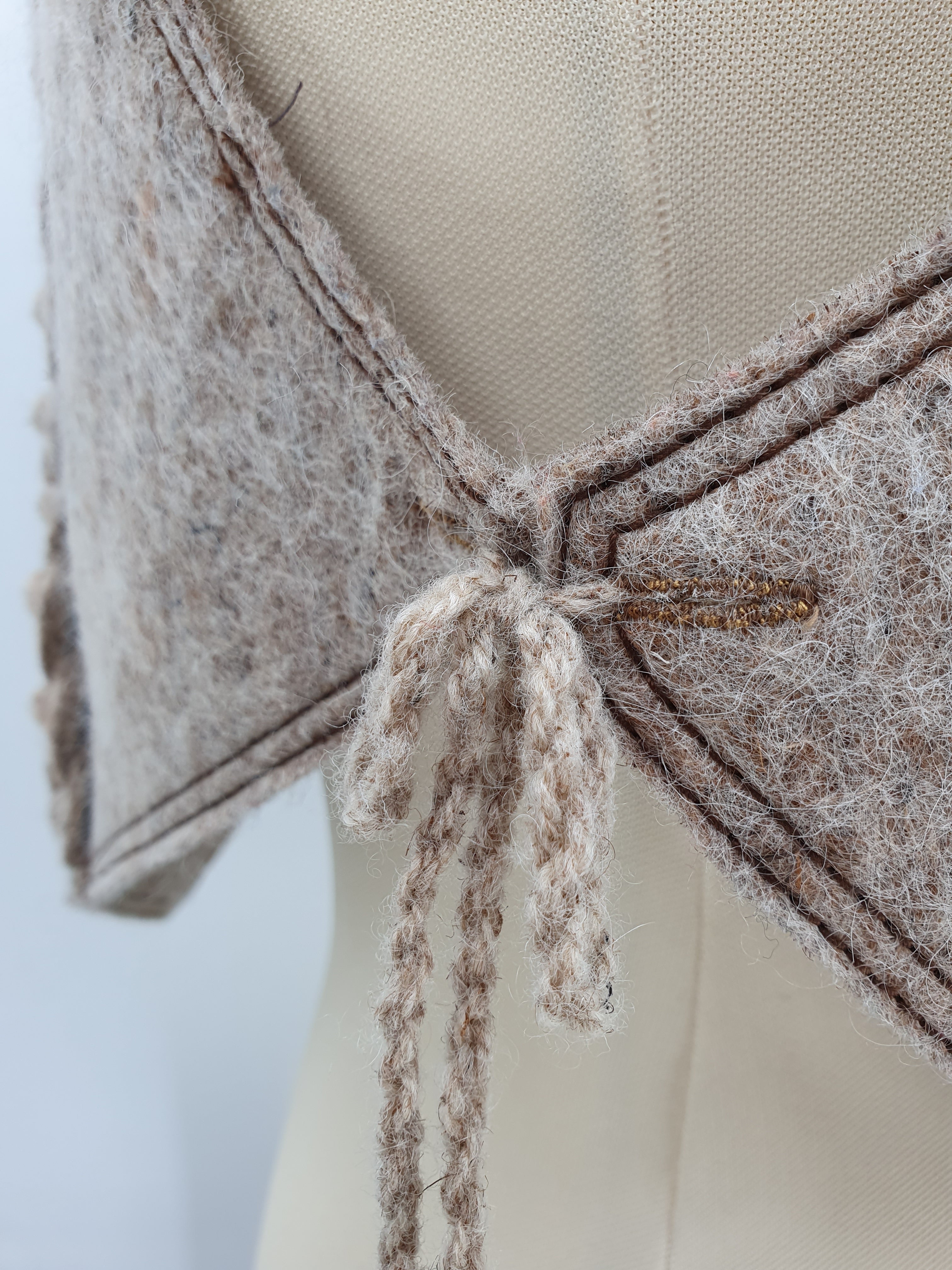 Beigen värinen villainen huopaliivi Unisex-malli Käsityönä valmistettu Kuva kiinnitysnaruista